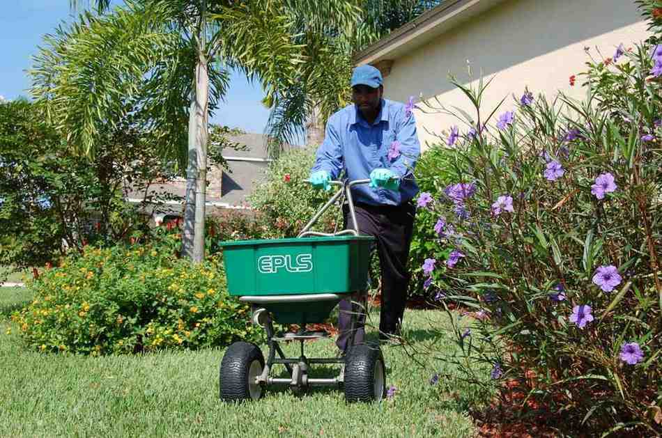 A Lawn Care Professional Applying Fertilizer Treatment to a Residential Yard in Orlando, FL